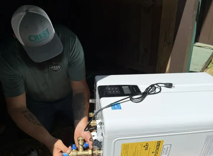 Crest Plumbing technician servicing a tankless water heater